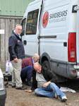 Friends helping to change a wheel